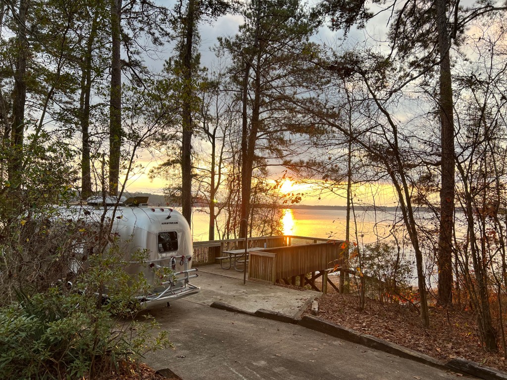 GenX Glamping Guy Airstream and sunset over a lake